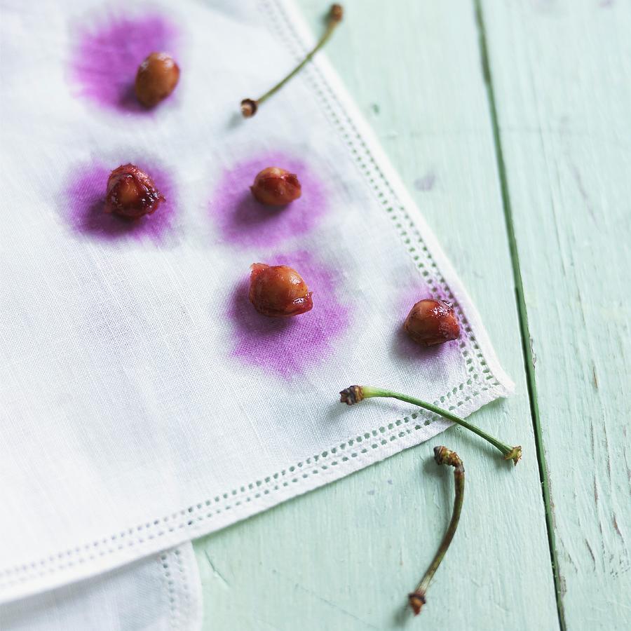 Fruit Photograph - Cherry Stones And Stems On A White Cloth by Vincent Noguchi Photography Fruit Photograph - Cherry Stones And Stems On A White Cloth by Vincent Noguchi Photography
