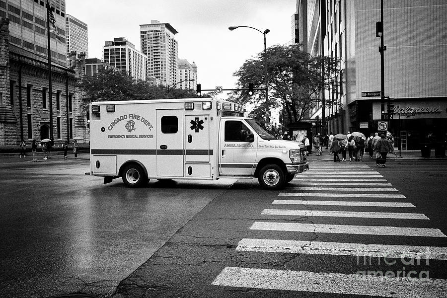 Chicago Photograph - Chicago Fire Department emergency ambulance on call on a wet day in downtown Chicago IL USA by Joe Fox
