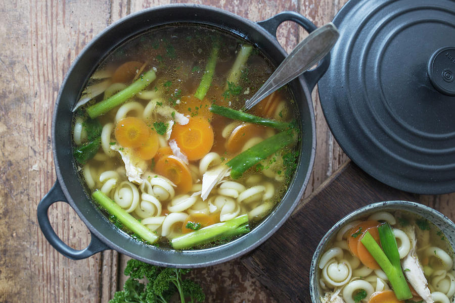 Chicken Soup With Pasta And Vegetables In A Cast Iron Pot Photograph by Nicole Godt