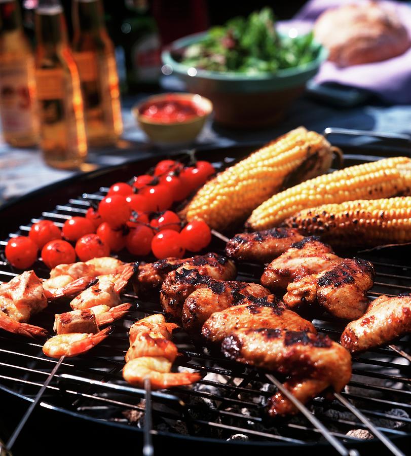 Chicken Wings, Prawn Skewers, Baby Sweetcorn And Tomatoes On The Barbecue Grill Photograph by Streeter, Clive