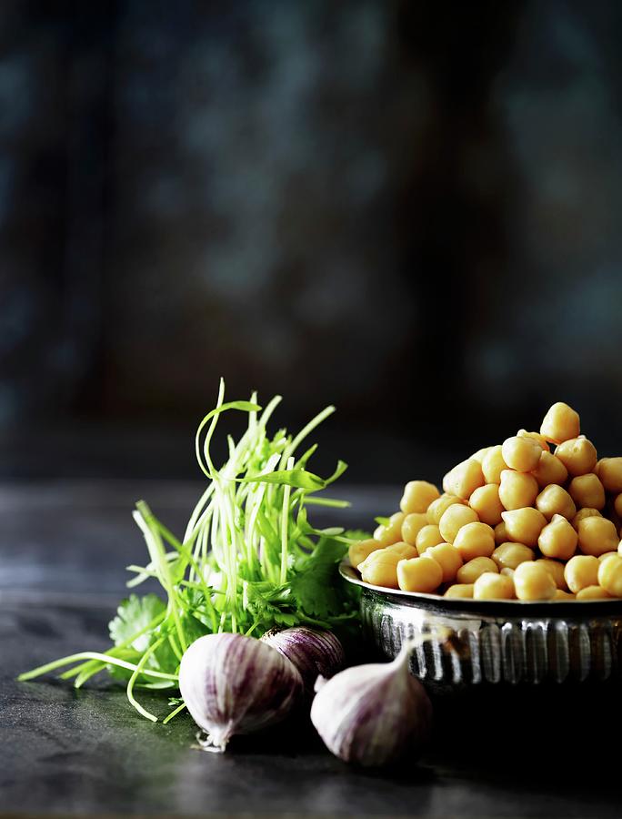 Chickpeas In A Metal Bowl With Garlic And Coriander Next To It Photograph by Mikkel Adsbl