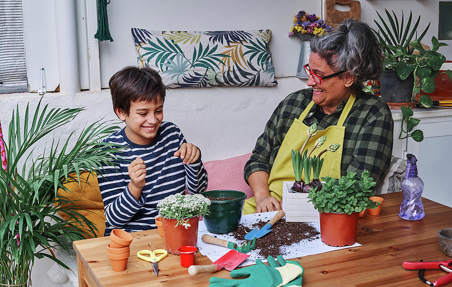 Nature Photograph - Child Learning And Having Fun With His Mother To Prepare Home Garden Plants In Spring by Cavan Images