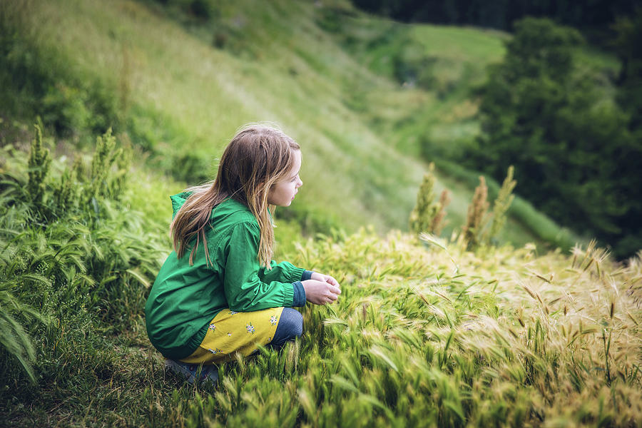 Child Looking Off Grassy Hillside In Belgrade, Serbia Photograph by ...