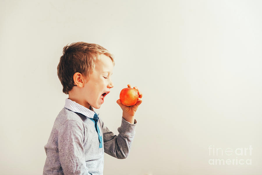Child ready to eat an apple at a bite, isolated on white backgro Photograph by Joaquin Corbalan