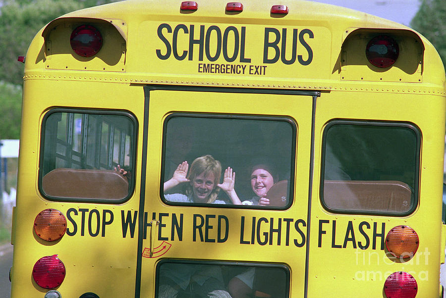 Children Waving From Back Of School Bus Photograph by Bettmann