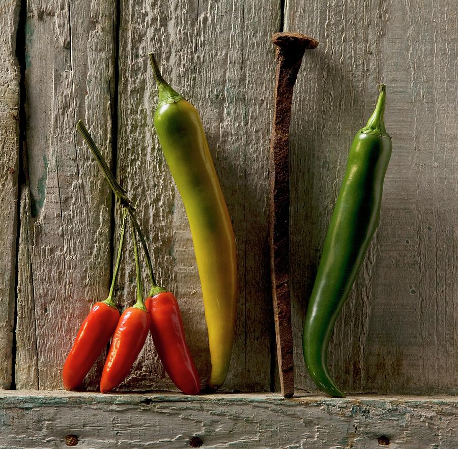 Chilli Peppers And A Rusty Nail Photograph by Blueberrystudio