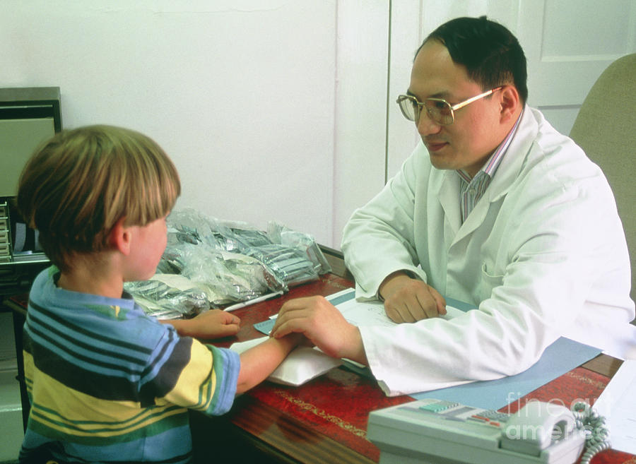 Chinese Medicine Practitioner Takes Boys Pulse Photograph by Mark Clarke/bath Chinese Medical Centre/science Photo Library
