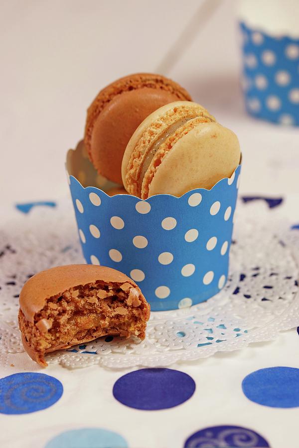 Chocolate And Cappuccino Macaroons In A Blue-and-white Paper Cup Photograph by Angelica Linnhoff