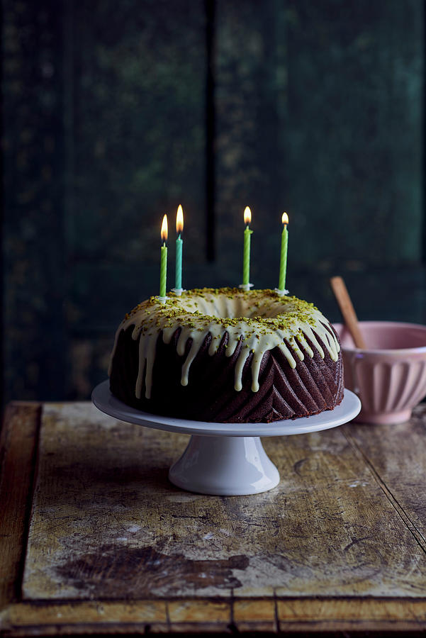 Chocolate Bundt Cake With A Pistachio Glaze And Four Burning Candles Photograph by Angelika Grossmann