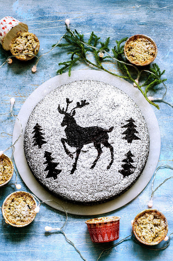 Chocolate Cake Dusted With Icing Sugar Through A Stencil Of Deer And Christmas Trees Photograph by Gorobina