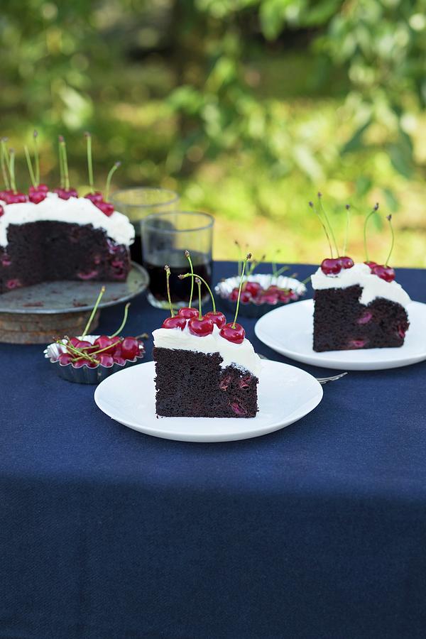 Chocolate Cake With Cream Cheese Frosting And Fresh Cherries On A Garden Table Photograph by Malgorzata Laniak