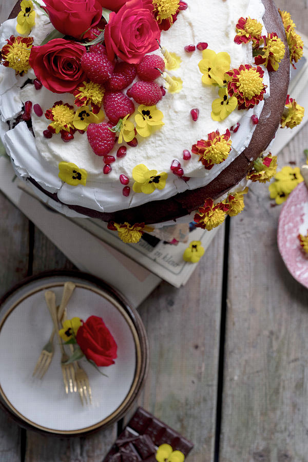 Chocolate Cake With Eatable Flowers Yellow And Red Roses, Raspberries And Whipped Cream On A Wooden Table With Plates Photograph by Lucie Beck