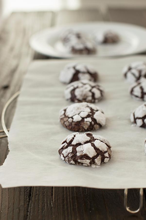 Chocolate Crinkle Cookies On A Piece Of Baking Paper Photograph by Alice Del Re