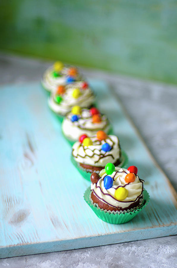 Chocolate Cupcakes In Green Paper Forms With Butter Cream And Colored Candies Photograph by Gorobina