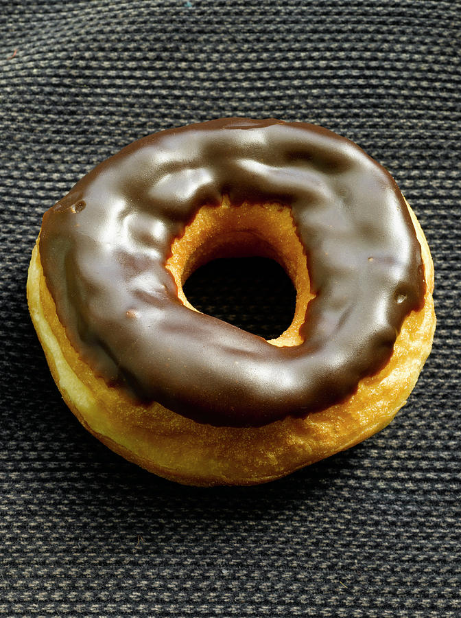 Chocolate Donut On A Black Mat Photograph by Howard Bjornson