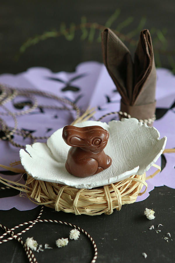 Chocolate Easter Bunny In Small Hand-made Ceramic Dish On Raffia Nest Photograph by Regina Hippel