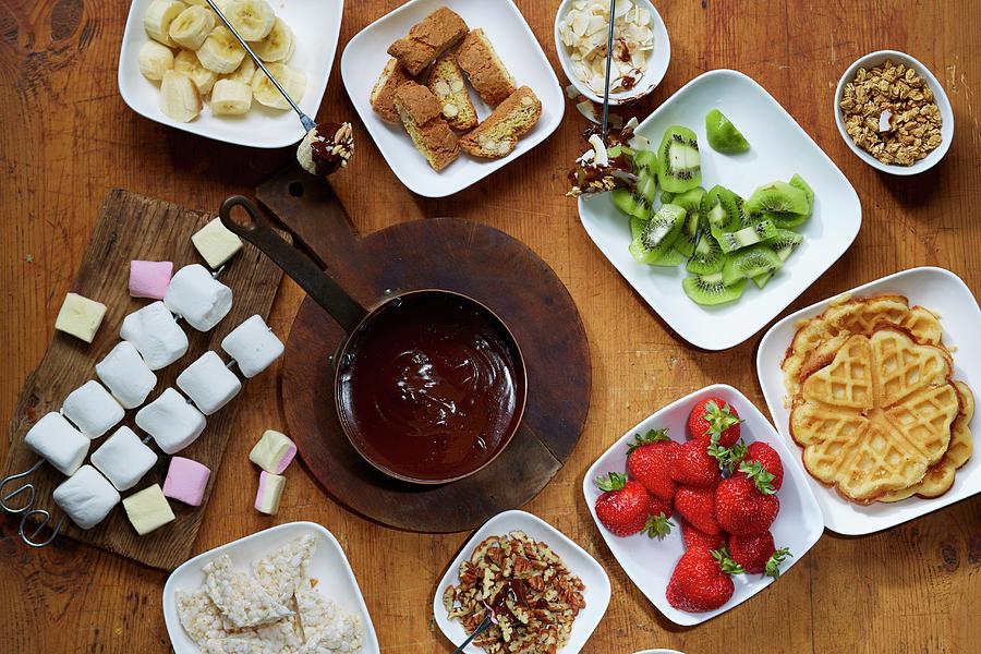 Chocolate Fondue With Fruit, Waffles, Marshmallows, Biscotti And Nuts Photograph by Frank Weymann