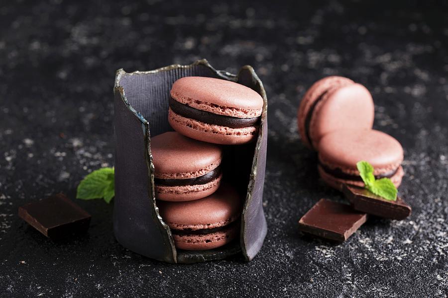 Chocolate French Macarons With Ganache Filling On A Black Table Photograph by Elena Veselova