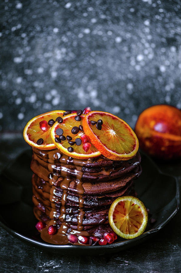 Chocolate Pancakes With Chocolate Drops, Sprinkled With Chocolate Sauce, Decorated With Slices Of Red Oranges Photograph by Gorobina