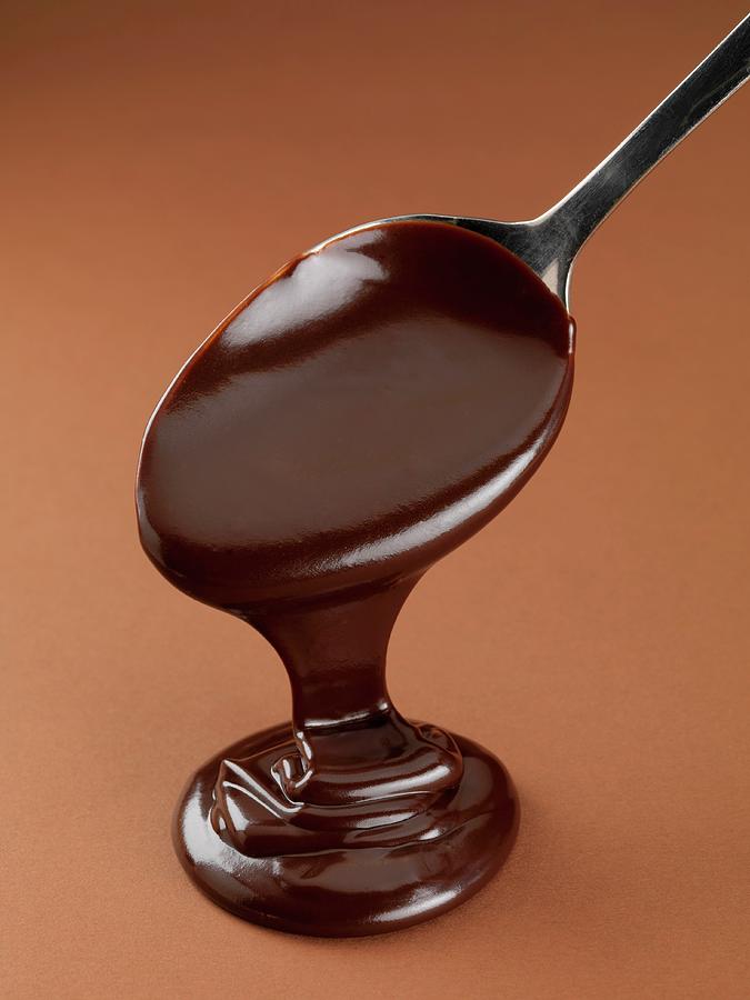 Chocolate Sauce Running Off A Spoon Photograph by Jim Scherer