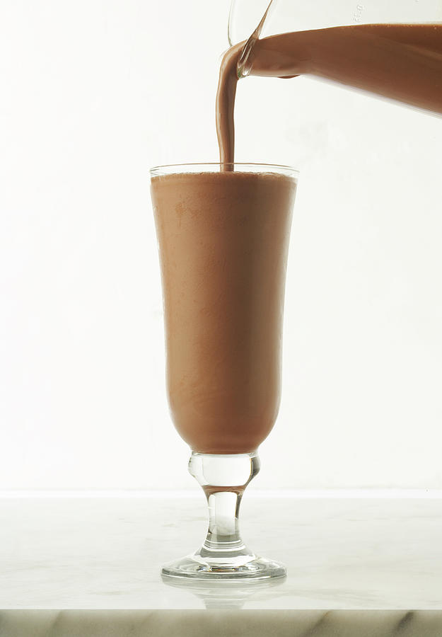 White Background Photograph - Chocolate Shake Being Poured Into Glass by James And James