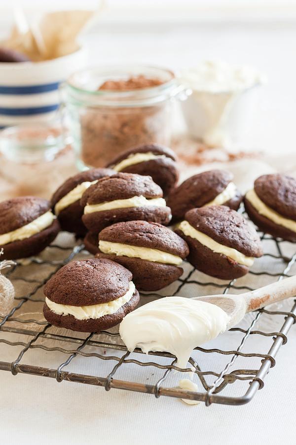 Chocolate Whoopie Pies Filled With Cream On A Wire Rack Photograph by Andrew Young
