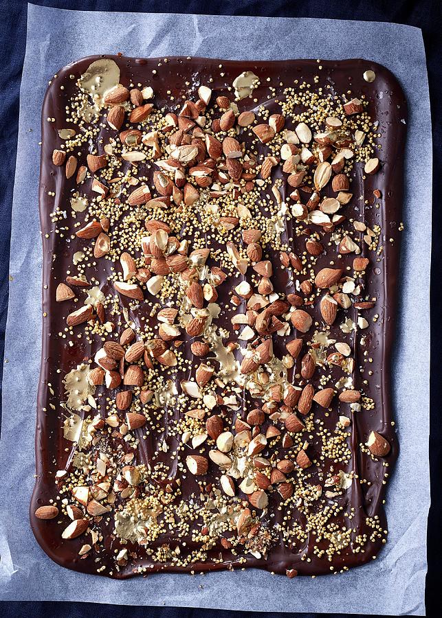 Chocolate With Almonds, Sea Salt, And Roasted Millet On Baking Paper Photograph by Great Stock!