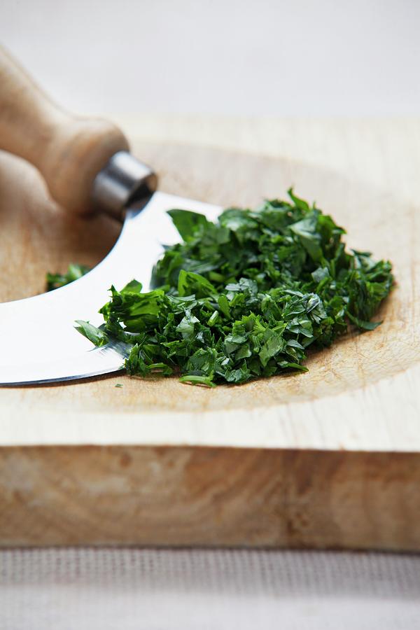 Chopped Parsley With A Chopping Knife On A Wooden Board Photograph by