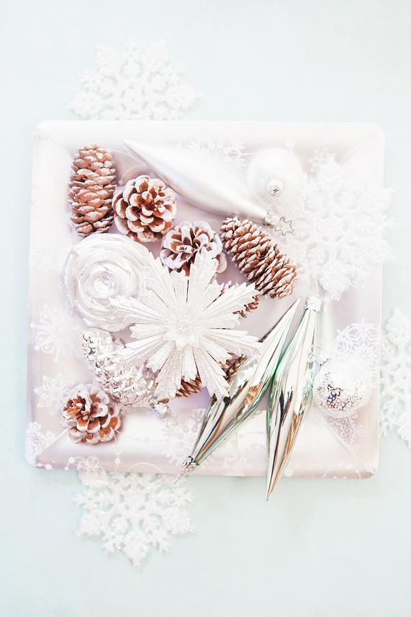 Christmas Arrangement Of Fir Cones Sprayed White And Stylised Snowflakes On Square Dish Photograph by Anneliese Kompatscher
