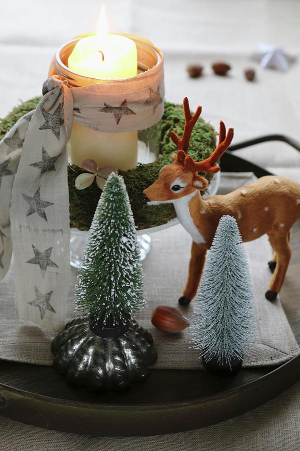 Christmas Arrangement Of Miniature Christmas Trees, Deer Ornament And Lit Candle In Glass Inside Moss Wreath Photograph by Regina Hippel