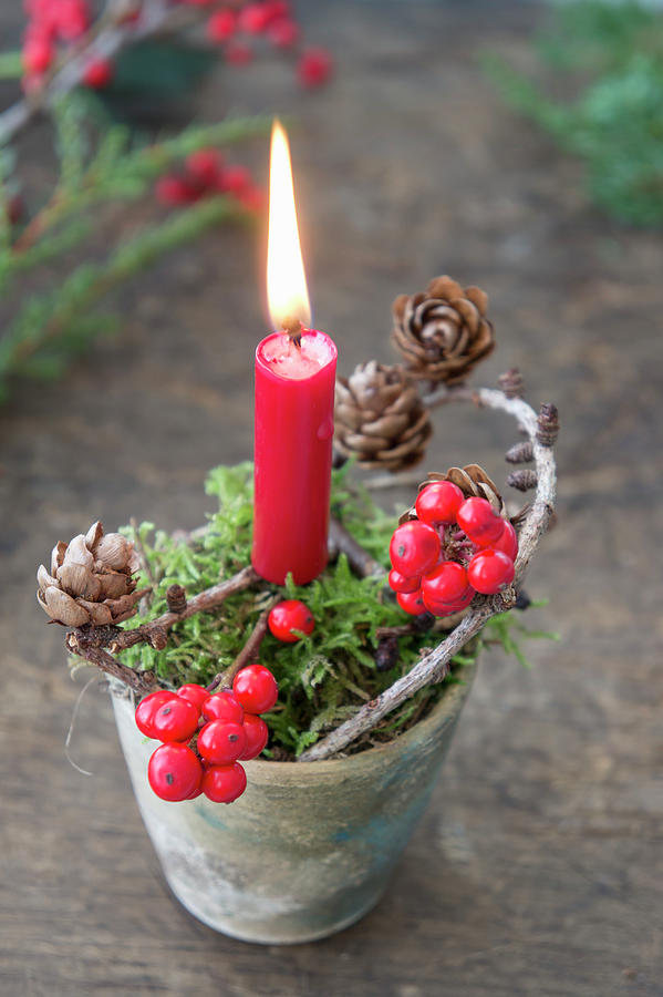 Christmas Arrangement Of Moss, Candle, Holly And Larch Cones In Clay Pot Photograph by Martina Schindler