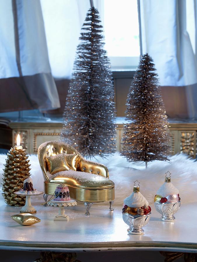 Christmas Baubles And Miniature Gilt Chaise Longue In Front Of Christmas Tree Ornaments Photograph by Matteo Manduzio