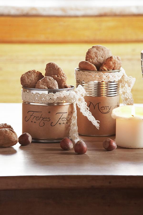 Christmas Biscuits In Tin Cans With Hand-written Labels And Nuts On Table Photograph by Heidi Frhlich