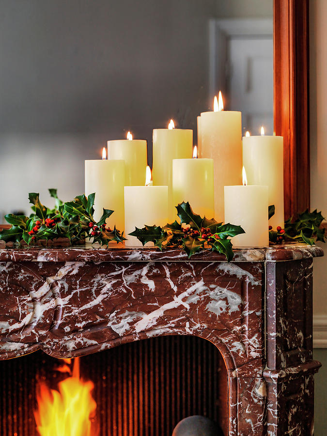 Christmas Candles On Mantelpiece With Holly And Open Fire Photograph by Michael Paul