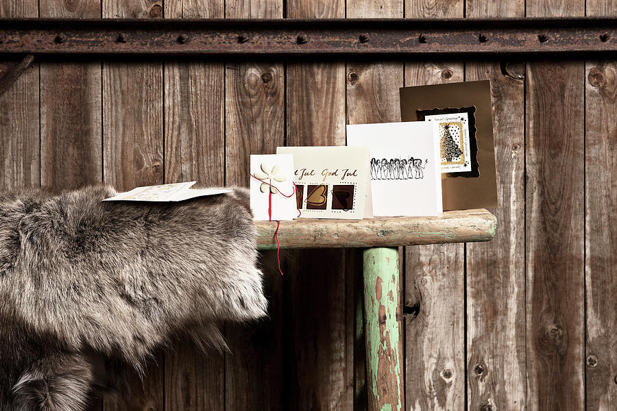 Christmas Cards And Elk Hide On Bench In Front Of Rustic Board Wall Photograph by Lykke Foged & Morten Holtum