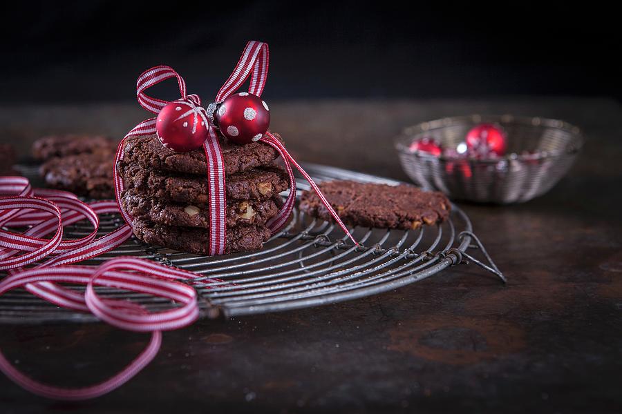 Christmas Chocolate And Walnut Cookies Wrapped In Gift Ribbon With A Bauble Decoration Photograph by Elisabeth Von Plnitz-eisfeld