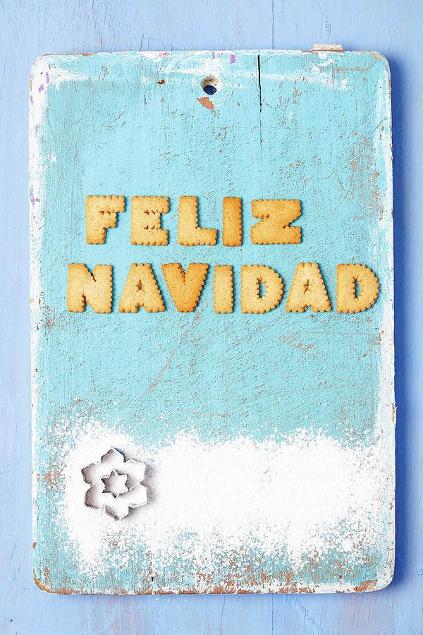 Christmas Greetings Written With Biscuits In Spanish And Cutters Photograph by Rua Castilho