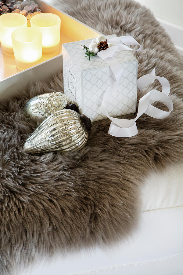 Christmas-tree Bauble, Gift Box And Tray Of Tealights On Fur Rug Photograph by Catja Vedder