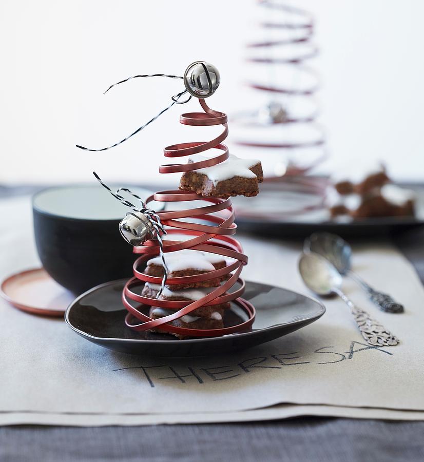 Christmas Tree Ornaments Made From Coiled Copper Wire, Bells And Cinnamon Stars Decorating Table Photograph by Andreas Hoernisch