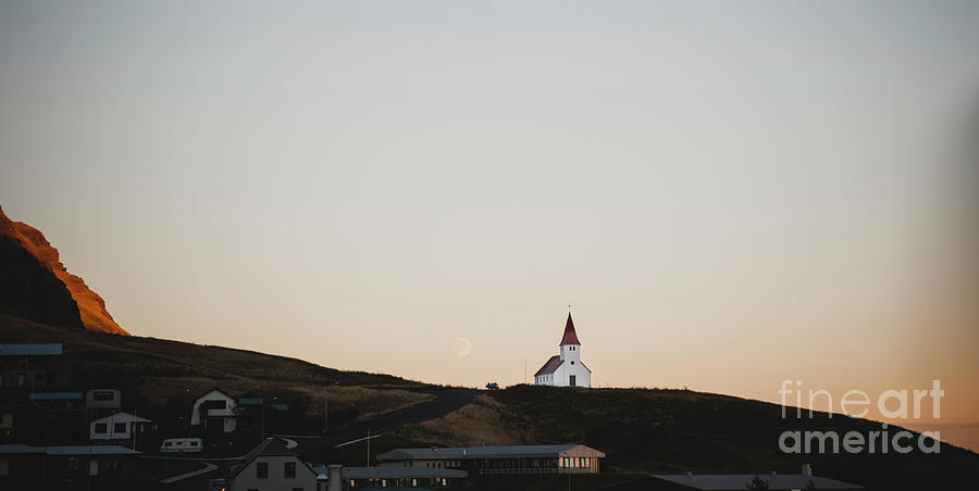 Church on top of a hill and under a mountain, with the moon in the background. Photograph by Joaquin Corbalan