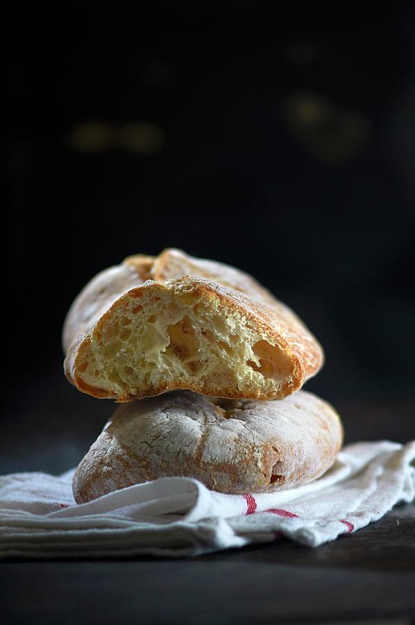 Ciabatta, Whole And Sliced, On A Tea Towel Photograph by Christoph Maria Hnting