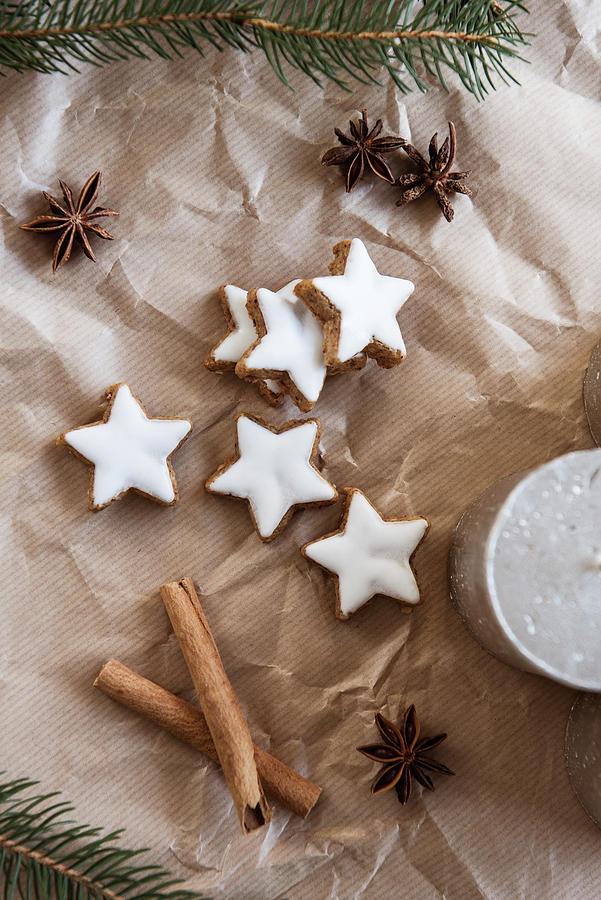 Cinnamon Star Biscuits, Cinnamon Sticks, Star Anise, Candle And Fir Branches On Brown Paper Photograph by Jelena Filipinski