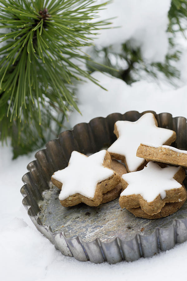 Cinnamon Stars In A Vintage Tart Tin In The Snow Photograph by Martina Schindler