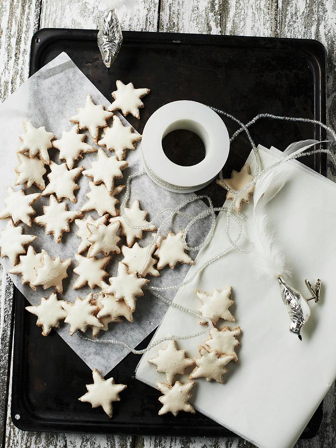 Cinnamon Stars On A Baking Tray With Silver Bird Figures Photograph by Hannah Kompanik