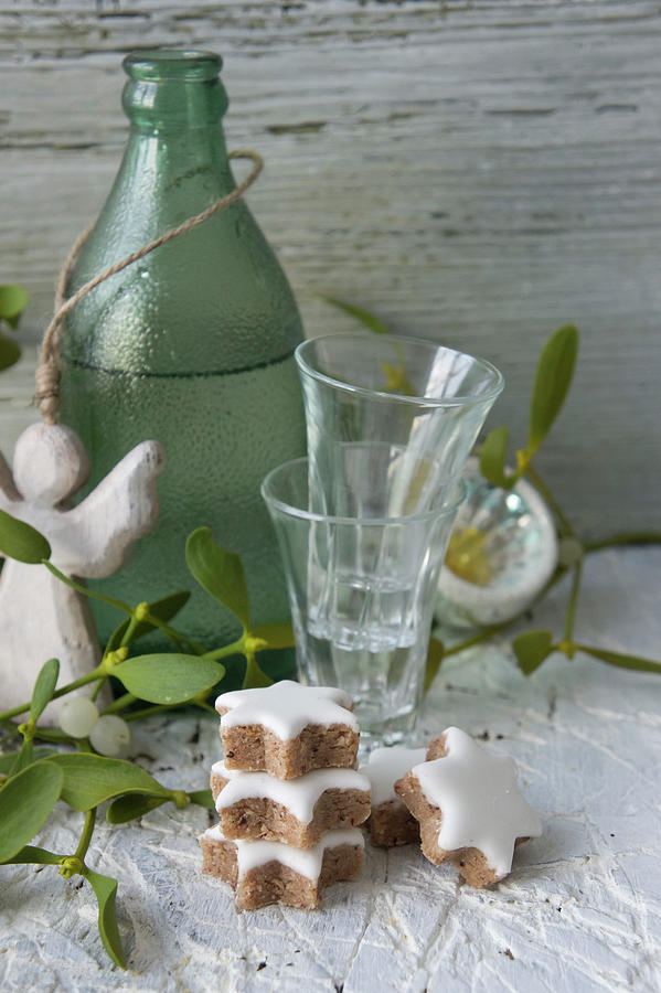Cinnamon Stars, Shot Glasses And Damson Water In A Green Bottle Photograph by Martina Schindler