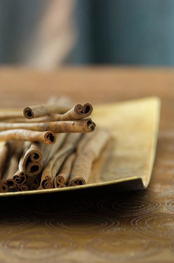 Cinnamon Sticks In The Golden Dish Photograph by Achim Sass