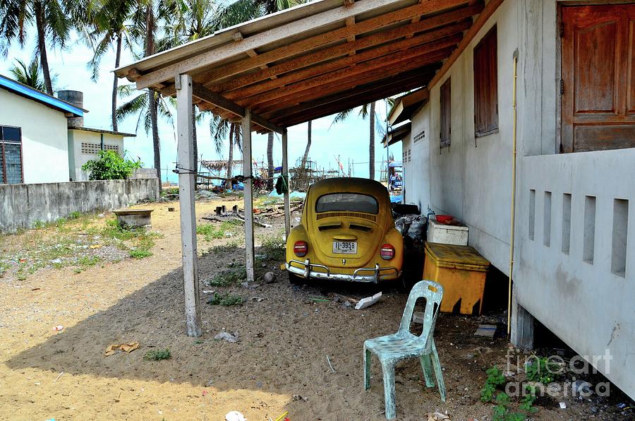 Classic German Volkswagen Beetle yellow car parked under shelter in Pattani Thailand Photograph by Imran Ahmed