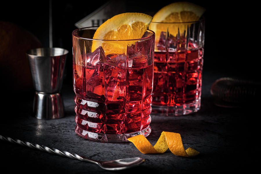 Classic Italian Cocktail: Negroni On Ice With Oranges In Glasses Photograph by Christian Kutschka
