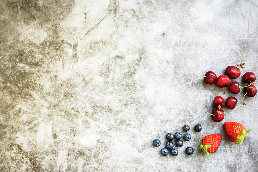 Clean background with a lot of negative space for healthy food, with red fruits on one side. Photograph by Joaquin Corbalan