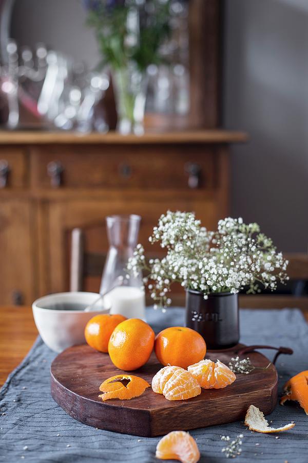 Clementines And Flowers On A Rustic Wooden Board Photograph by Eva Lambooij